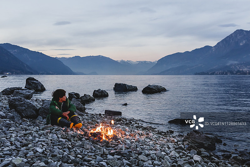 男孩和小篝火靠近湖边图片素材