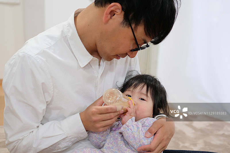 父亲在家给婴儿喂奶图片素材