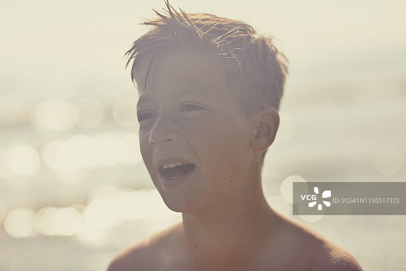 一个男孩的肖像有乐趣和在海滩上笑图片素材