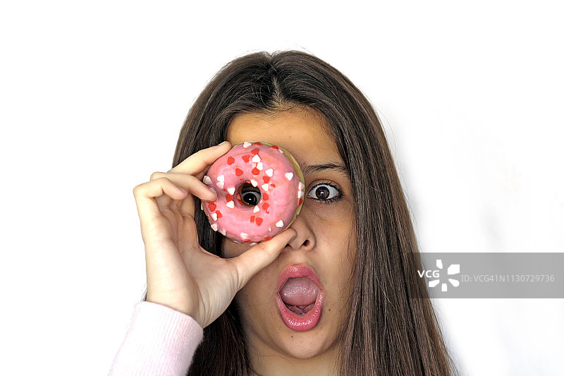 有趣的美女透过粉色的甜甜圈看。饮食,饮食的概念。垃圾食品，减肥，减肥图片素材