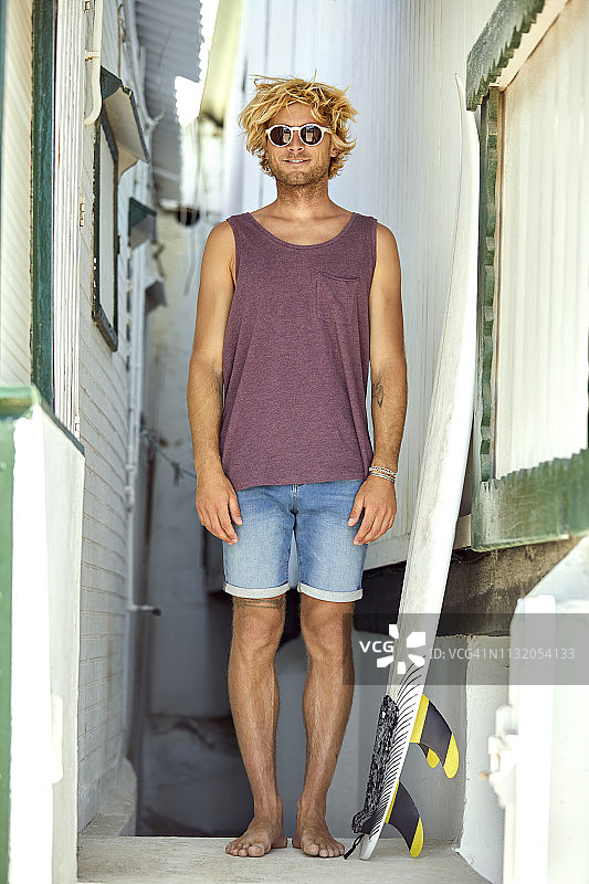 一个男人站在海滩小屋中间的画像图片素材