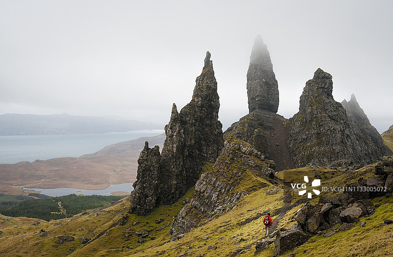 在一个雾蒙蒙的春日，一名导游走向苏格兰斯凯岛的斯托尔老人图片素材