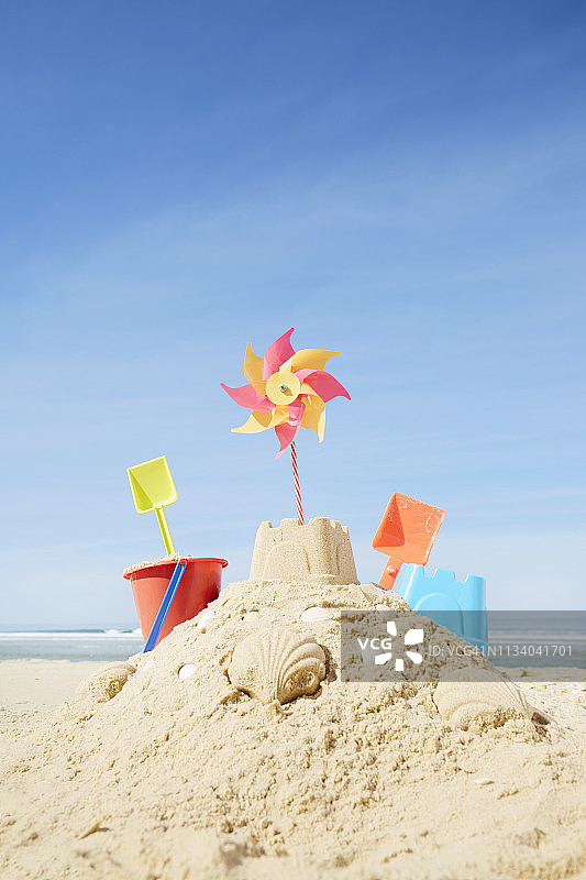 沙滩上的沙堡有五颜六色的沙玩具和风车图片素材
