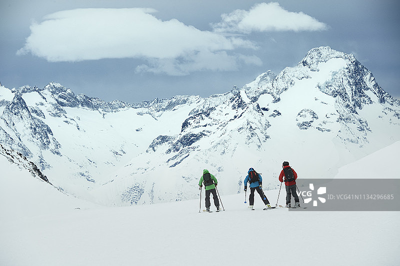 风景与三个男性滑雪者滑雪向山，后视图，阿尔卑斯，罗讷-阿尔卑斯，法国图片素材