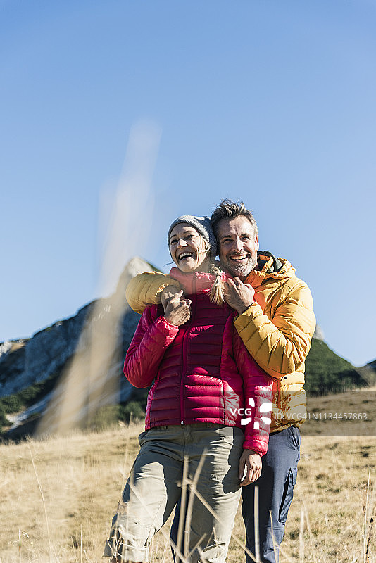 奥地利，蒂罗尔，一对幸福的情侣在山中徒步旅行时拥抱在一起图片素材