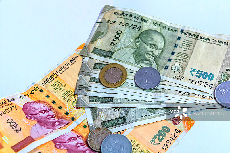 近距离观看全新的印度200、500卢比纸币和一些白色背景上的硬币。图片素材