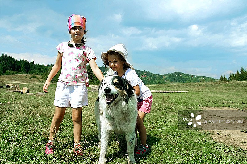 在罗马尼亚的特兰西瓦尼亚，姐妹俩带着她们照顾的一只狗一起翻山越岭图片素材