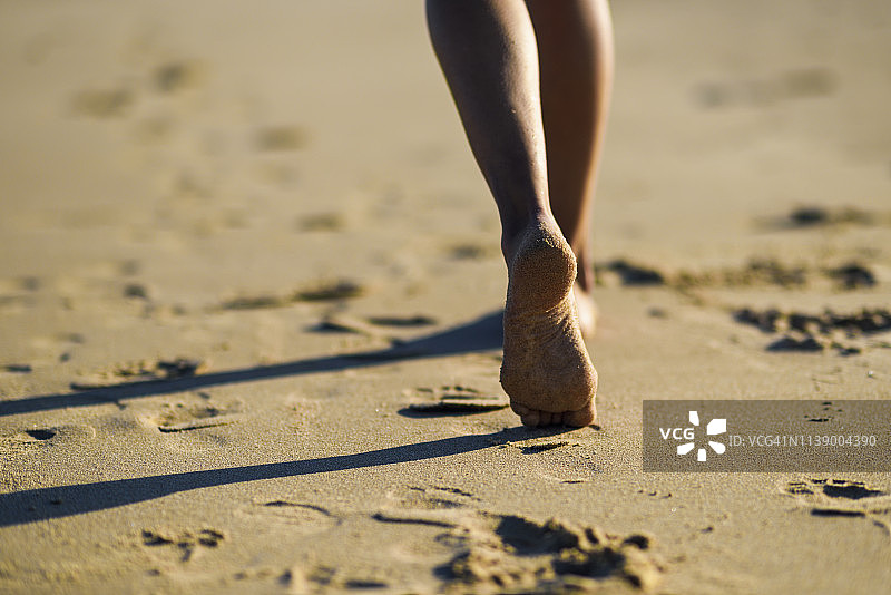 女人的脚在沙滩上行走的特写图片素材