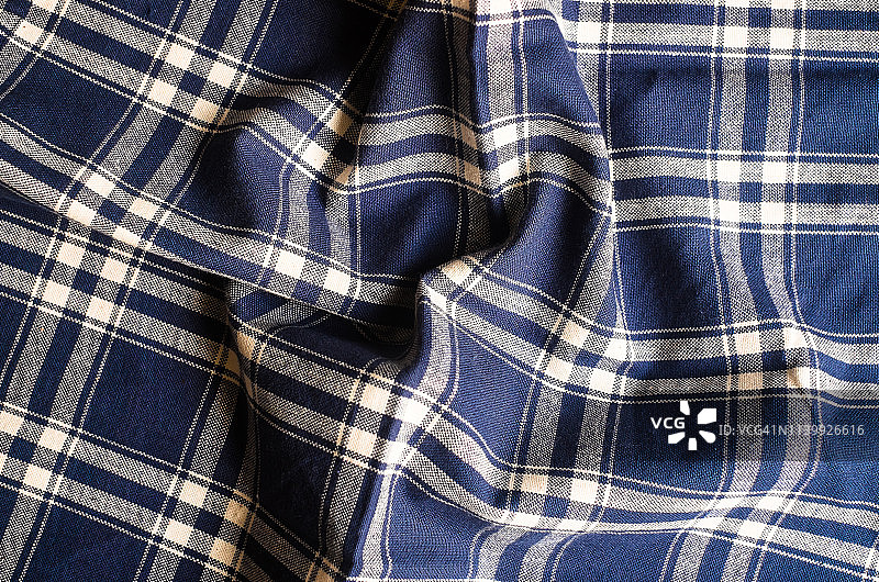 纺织品背景与格子蓝色餐巾，俯视图。天然纺织背景。织物纹理背景。天然亚麻织物的质地。图片素材