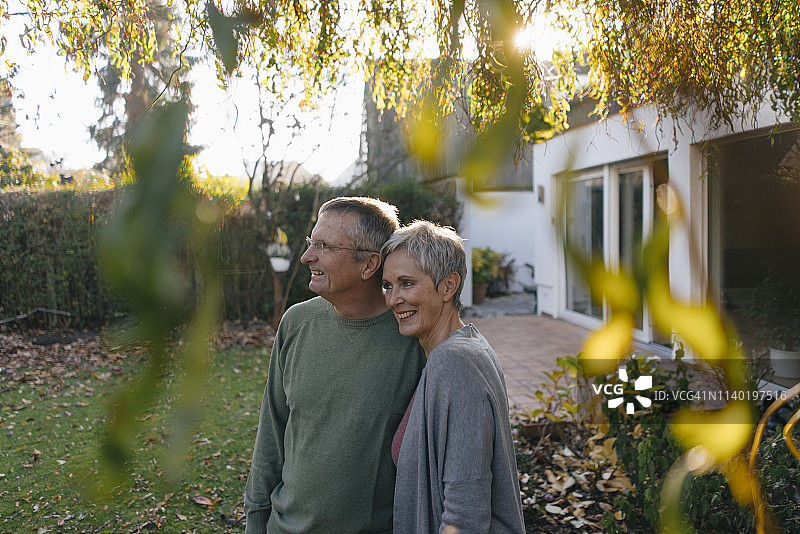 一对快乐的老年夫妇在花园里环顾四周图片素材