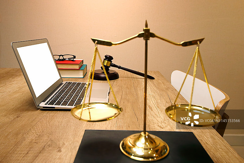 正义与法律观念。律师工作时桌上放着笔记本电脑图片素材