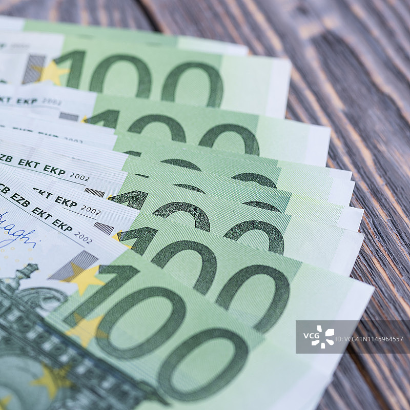 黑色木制背景上的欧元现金钞票。图片素材