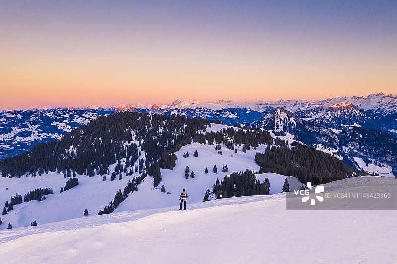 一名男子在瑞士的雪山上欣赏美景图片素材