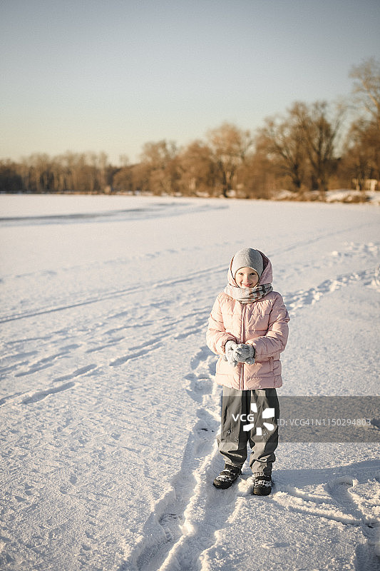 小女孩站在雪地上的肖像图片素材