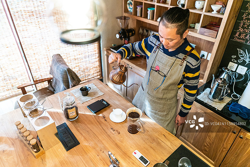 成熟的中国男人在咖啡实验室煮咖啡图片素材