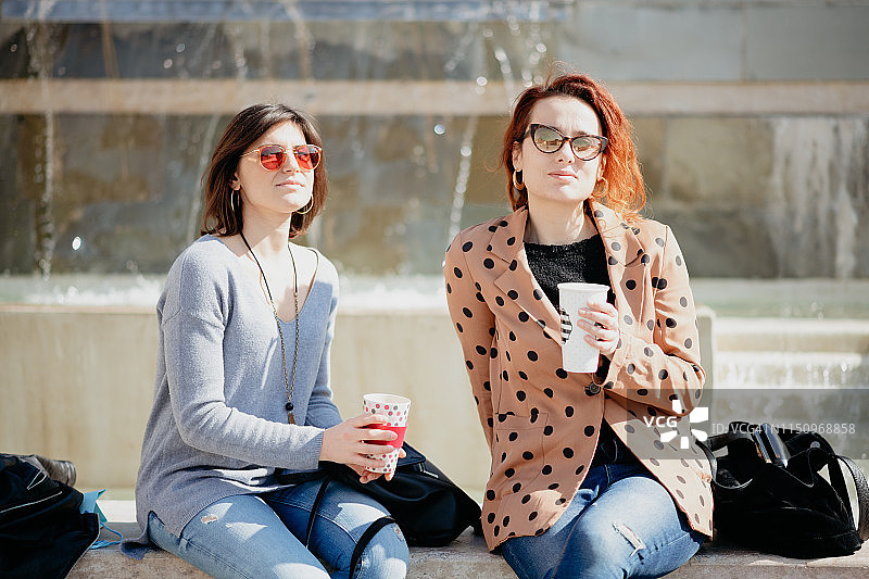 意大利托斯卡纳，阿雷佐，闺蜜们在喷泉前喝咖啡休息图片素材