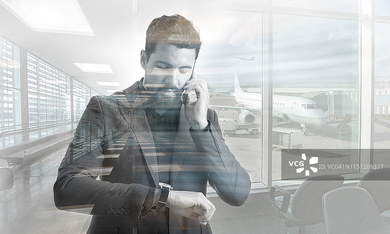 一名男子在机场边看时间边用智能手机打电话图片素材