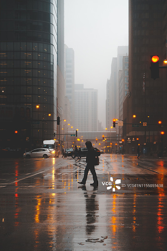 一个人过马路的剪影在一个雾蒙蒙的晚上，芝加哥，伊利诺斯州，美国图片素材