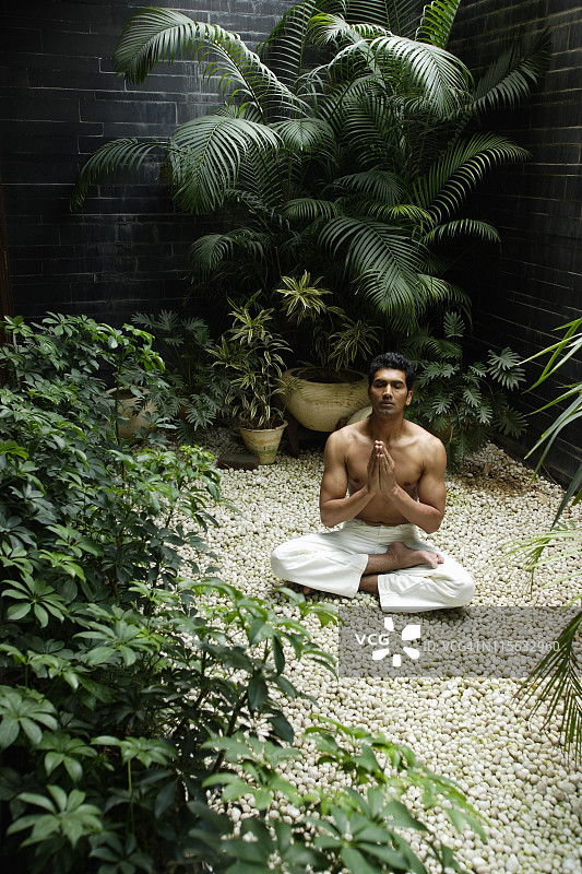 一个人在植物的包围下练习瑜伽图片素材