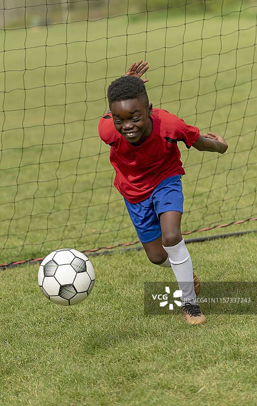 汉普郡，英格兰，英国，一个年轻的足球运动员在一个公园的训练中防守球门。图片素材