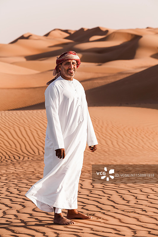 穿着民族服装的贝都因人站在阿曼瓦希巴沙漠图片素材
