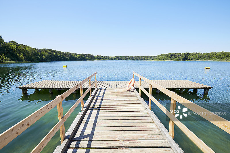 碧空映衬下的田园诗般的湖泊边的码头图片素材