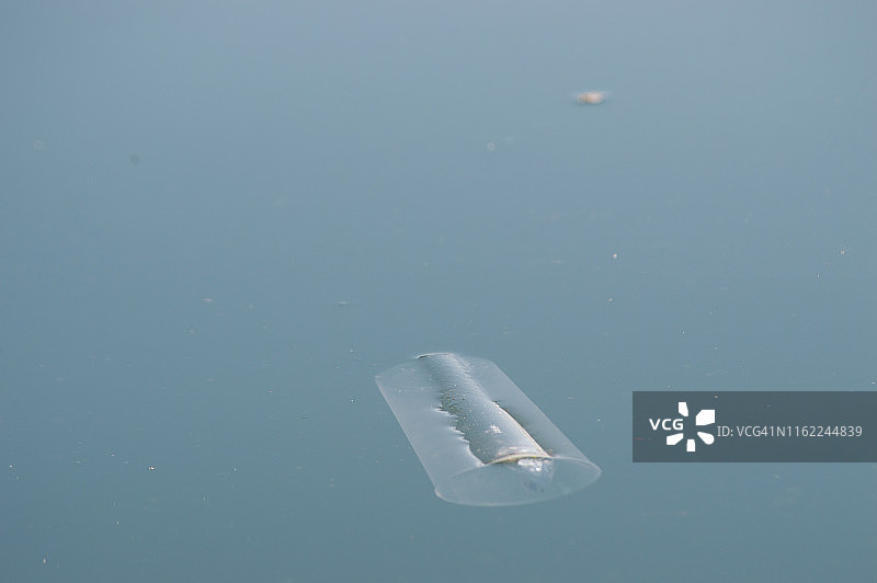 塑料杯漂浮在海上，海岸线污染图片素材