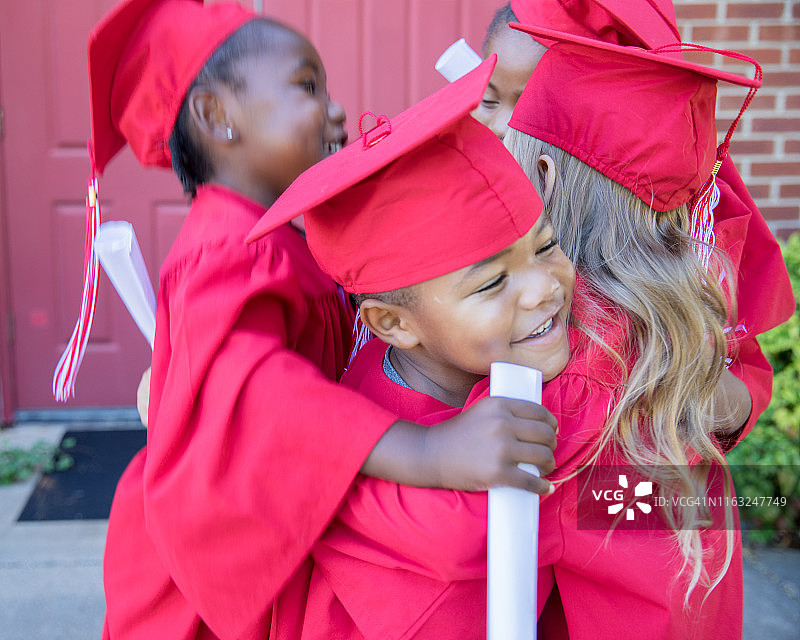 一群可爱的学龄前儿童毕业后拥抱跳跃图片素材