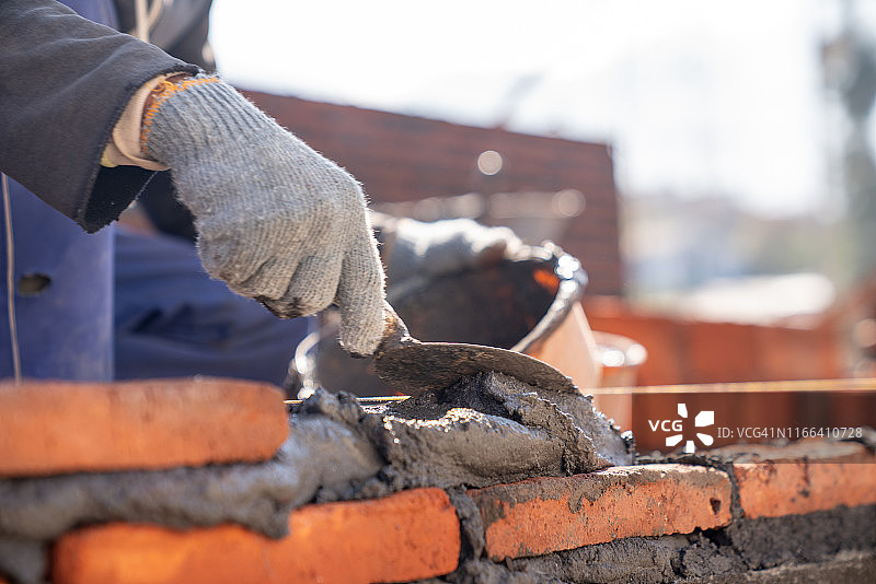 砌砖工工业工人在建筑工地用泥刀安装砌砖图片素材