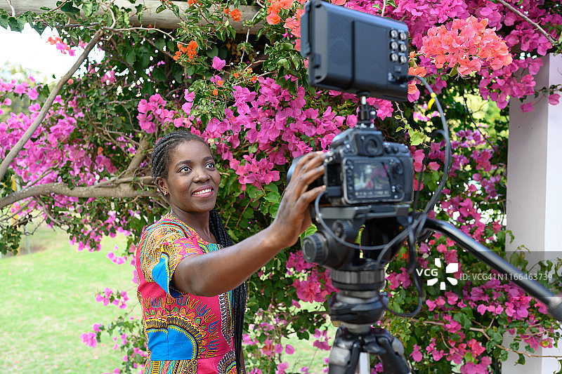 年轻的非洲妇女为视频博客架设摄影机图片素材