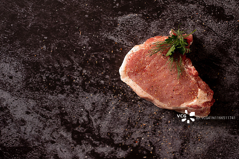 生肉，牛排在黑色背景，俯视图图片素材
