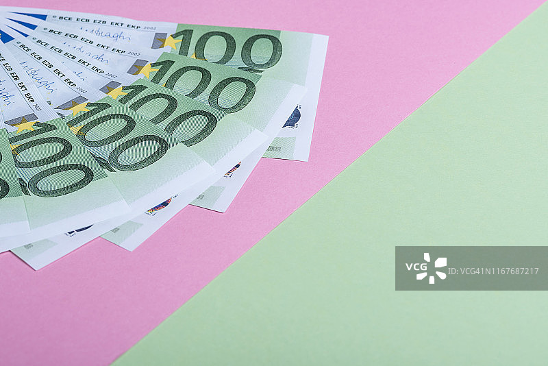 粉红和绿色背景的欧元现金。欧元纸币。欧元的钱。欧元的法案。文本。图片素材
