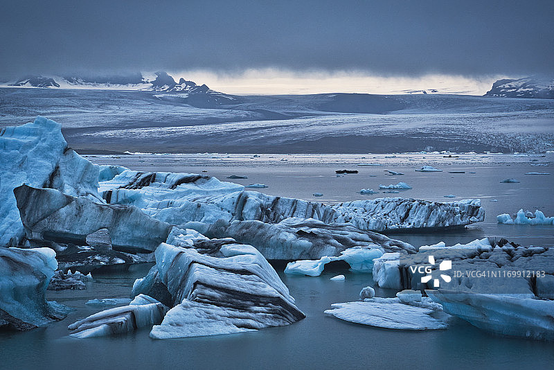 冰山在Jokulsarlon礁湖和戏剧性的云图片素材