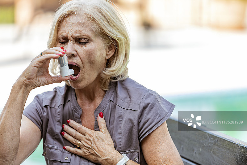 哮喘妇女使用吸入器图片素材