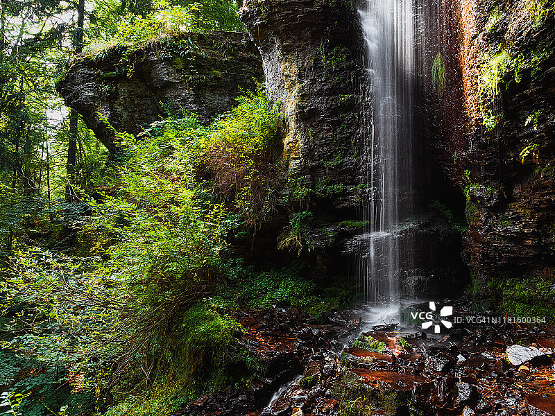 夏季森林景观与长时间暴露美丽的瀑布从岩石悬崖流动。喀尔巴阡山脉的瓦萨格瀑布图片素材