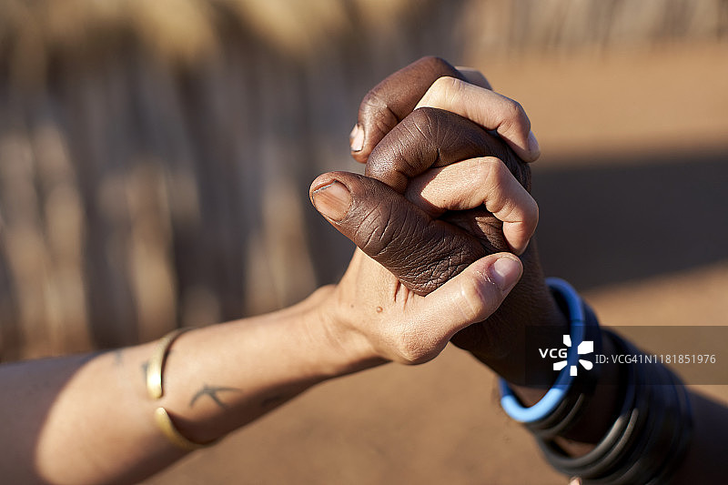 安哥拉奥考卡，传统女性和白人女性手牵手图片素材
