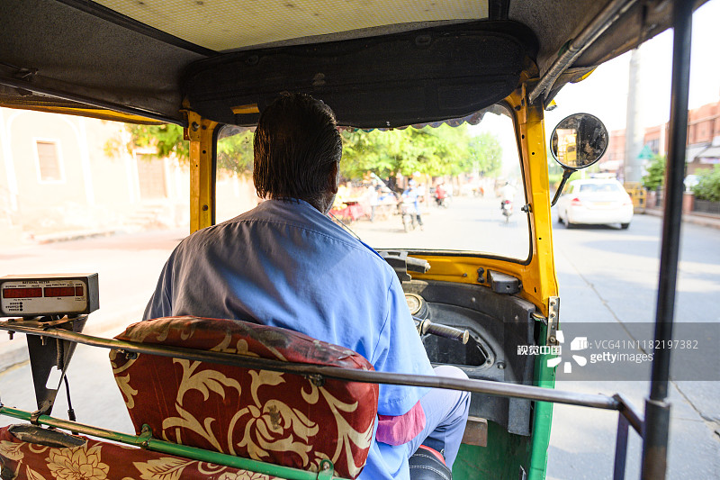 一名身份不明的司机骑着机动三轮车穿过斋浦尔繁忙的街道。图片素材