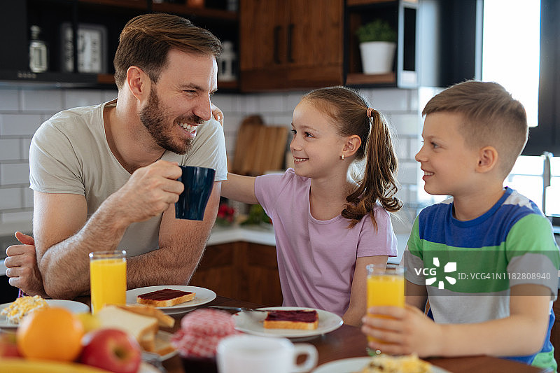 父亲和孩子们在家吃早餐图片素材