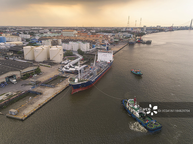 鸟瞰图拖船拖着油轮从炼油厂装货码头在海上运输。图片素材