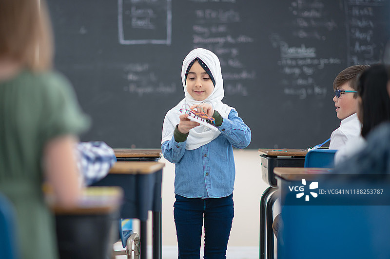 穆斯林女孩向她的班级献礼图片素材