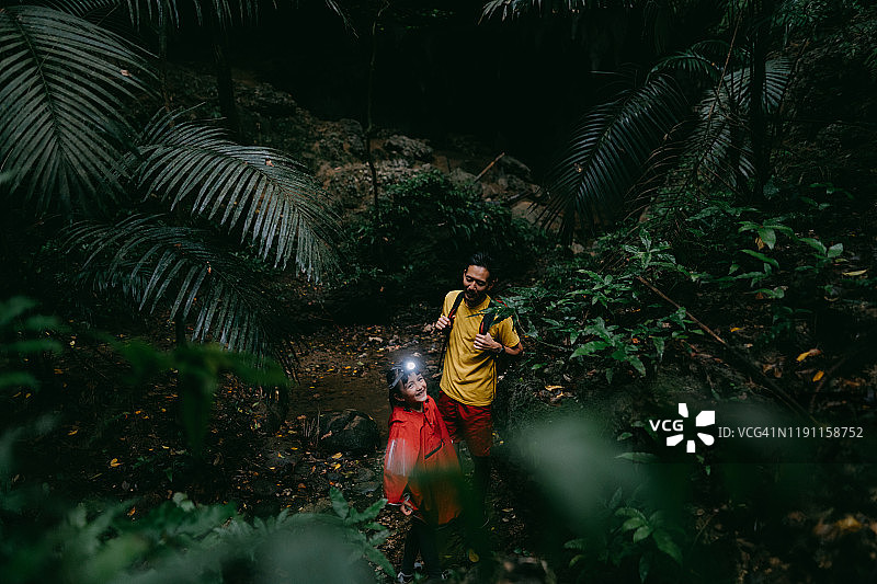 小女孩和父亲徒步穿越丛林洞穴，Iriomote岛，冲绳，日本图片素材