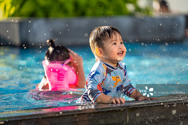 越南语——快乐的孩子在池子里玩水花图片素材