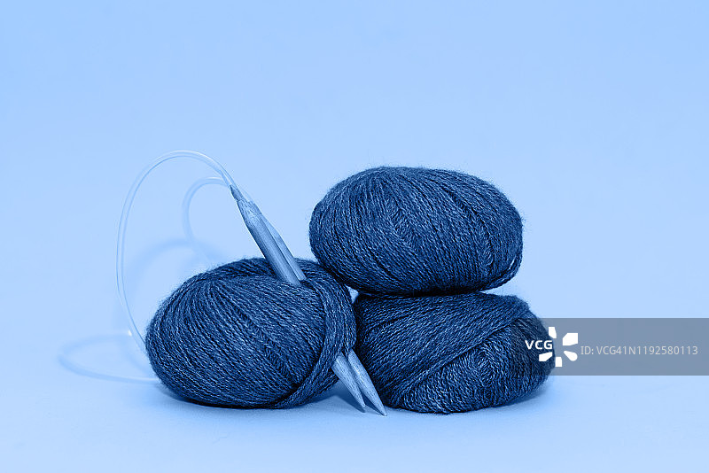 彩色线用于针织，编织围巾，编织针在深色背景上。副本的空间。针织的概念图片素材