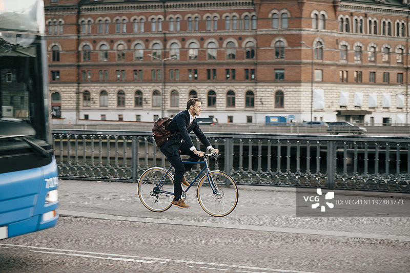 在城市道路上骑自行车的商人图片素材