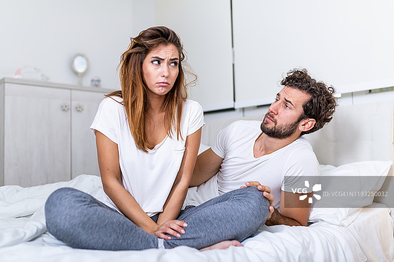 在床上有分歧的夫妇。一对沮丧的夫妇争吵，有婚姻问题，年轻夫妇在卧室的床上争吵图片素材