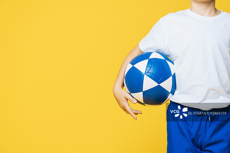 小男孩踢足球的黄色背景图片素材