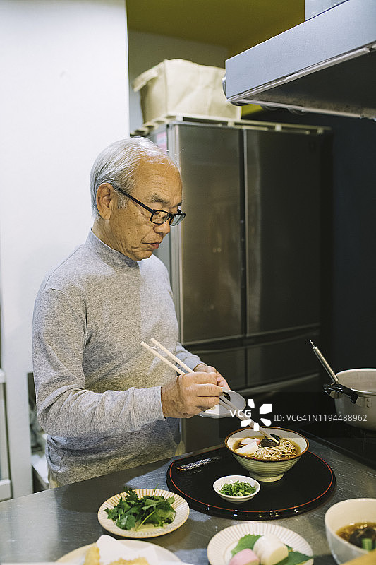 年长的亚洲人在厨房做饭图片素材