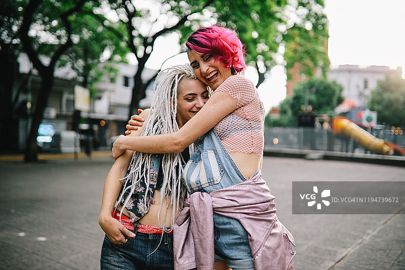 两个女孩在街上拥抱图片素材