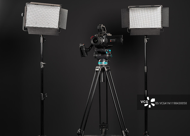 专业影院摄像机和两个发光LED面板在黑色背景图片素材