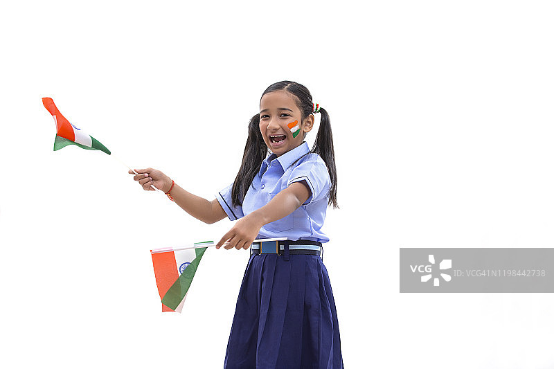 年轻的女学生脸上画着国旗，手里拿着国旗，独立日图片素材